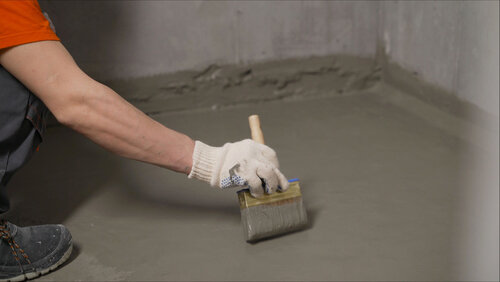 The process of applying mortar - waterproofing to a concrete floor. The concept of waterproofing the floor with a brush.