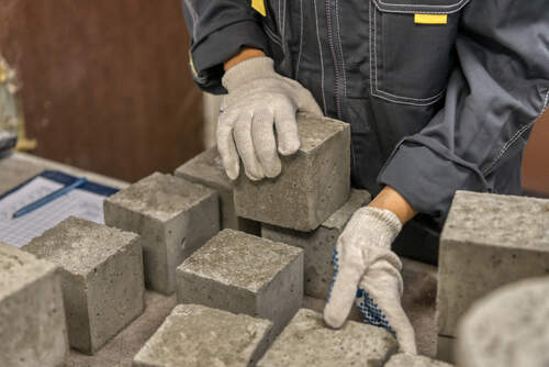 Laboratory for testing building materials. Lab technician selects concrete cubes for testing.